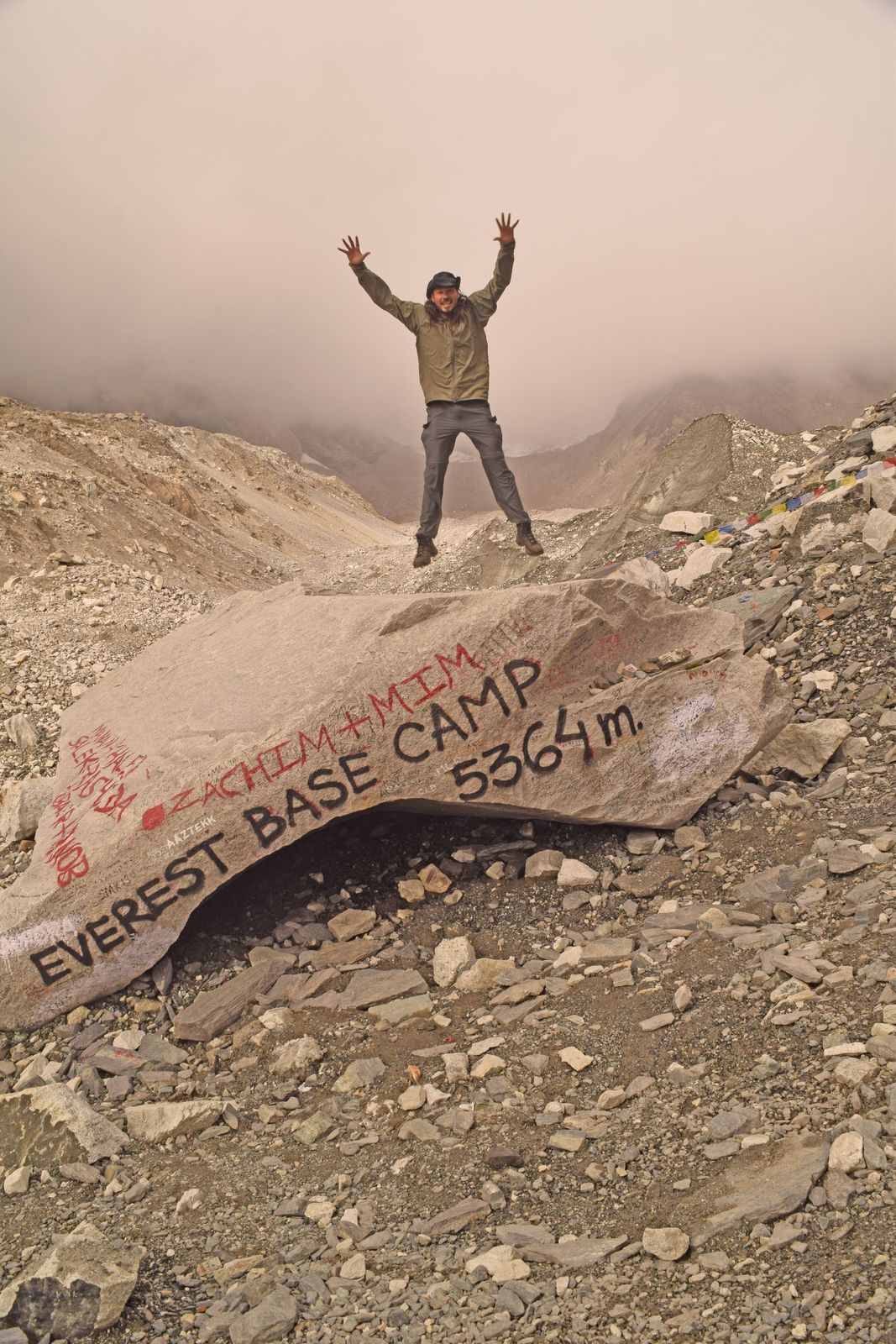 Lane Belone jumping above the spray-painted Everest Base Camp rock at 5,364 meters, with no expedition tents in September