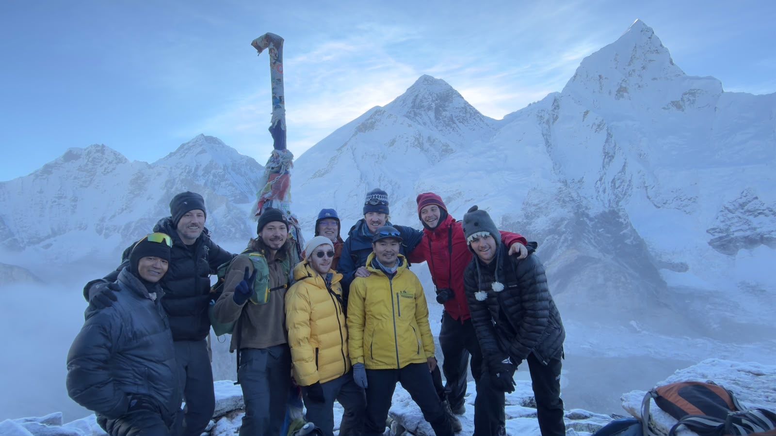The trekking group on top of Kala Patthar with Mount Everest and Nuptse behind them