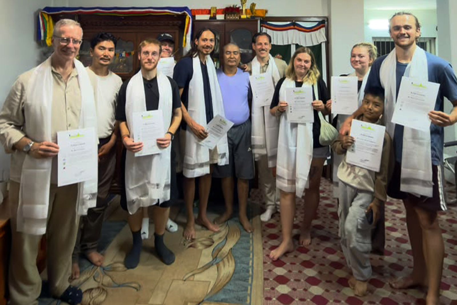 The trekking group with certificates and white blessing scarves at Wangda Sherpa's home in Kathmandu